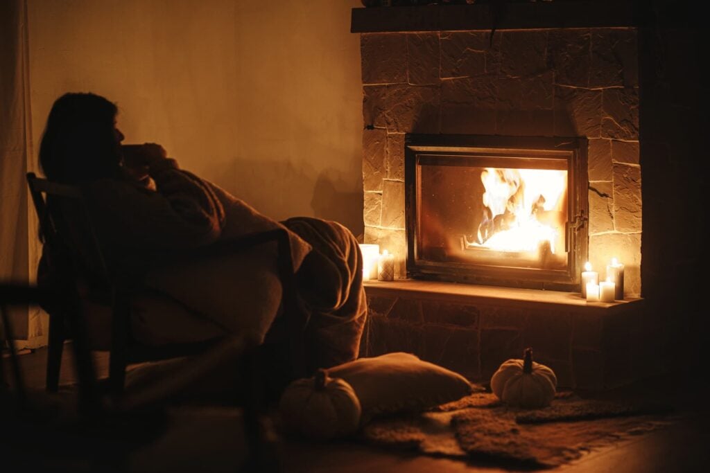 Lady sitting beside a firelight