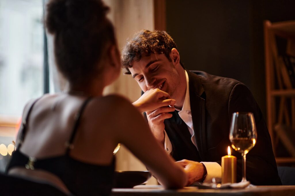 Handsome man kissing the hand of a lady at a date,